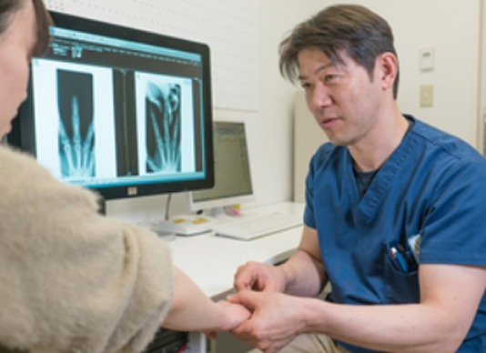 整形外科の医師が患者の骨レントゲン画像を見ている診療風景